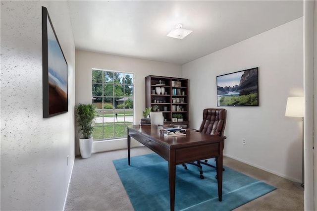 carpeted home office featuring baseboards
