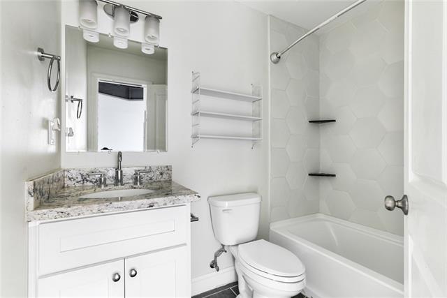 full bath featuring  shower combination, vanity, and toilet