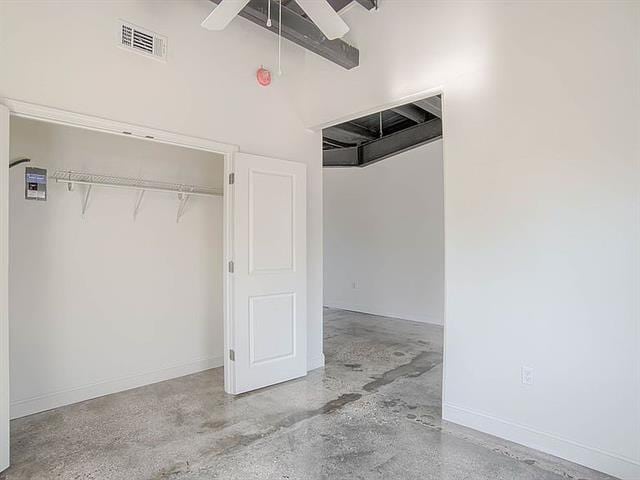 unfurnished bedroom with baseboards, ceiling fan, visible vents, and concrete flooring