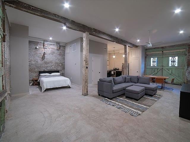 interior space with visible vents, ceiling fan, concrete floors, and beam ceiling