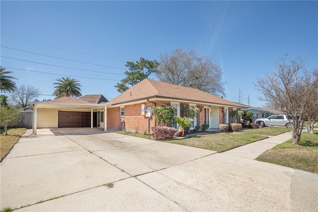 ranch-style house with an attached garage, a front yard, concrete driveway, and brick siding