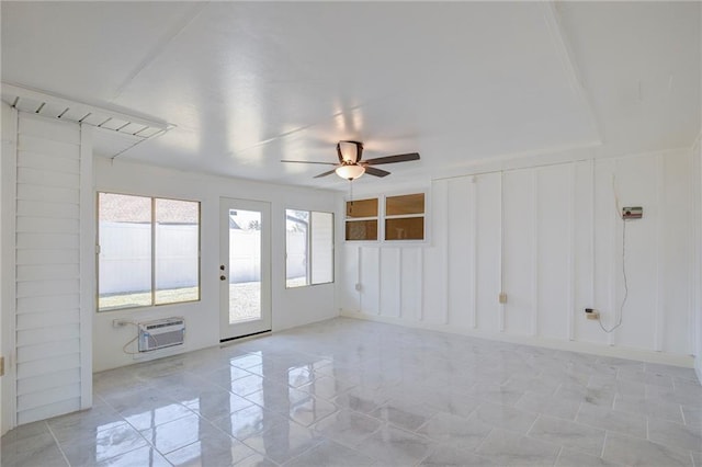 interior space with a ceiling fan, an AC wall unit, and a decorative wall