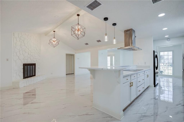 kitchen with marble finish floor, island exhaust hood, black electric cooktop, and freestanding refrigerator