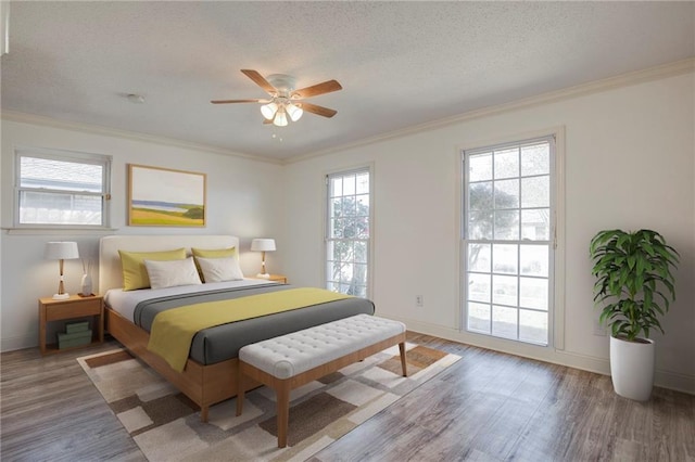 bedroom featuring baseboards, crown molding, and wood finished floors