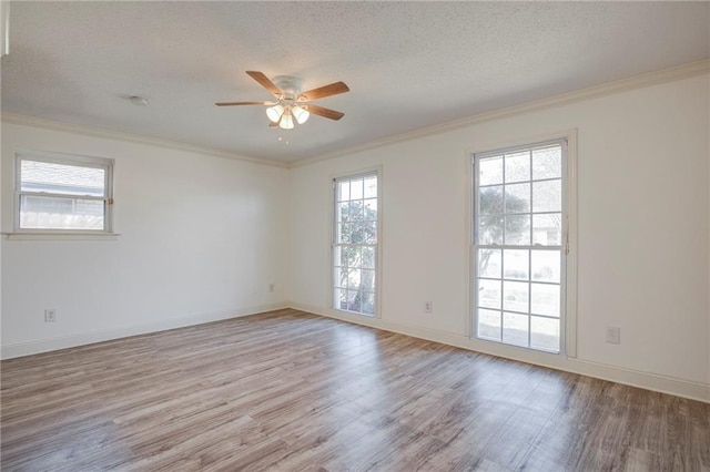 unfurnished room with crown molding, a textured ceiling, baseboards, and wood finished floors