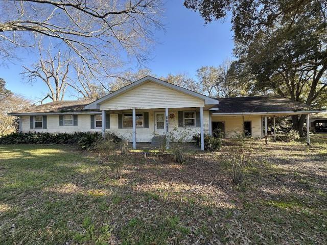 ranch-style house featuring a porch and a front yard