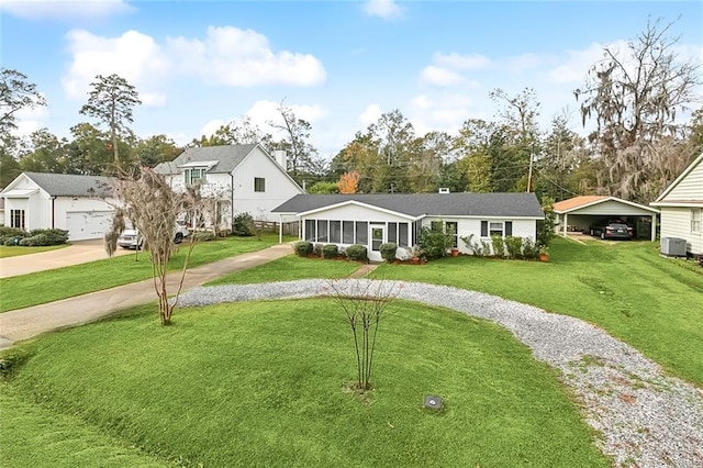 view of front of property featuring a front yard, a sunroom, driveway, and central AC unit