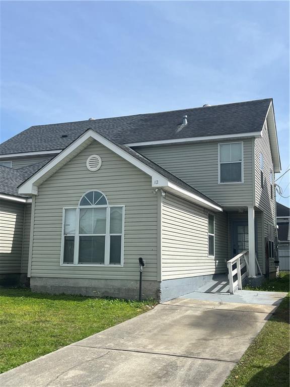 view of front of house with roof with shingles and a front lawn