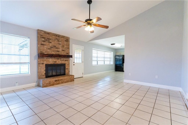 unfurnished living room featuring a fireplace, a ceiling fan, light tile patterned flooring, vaulted ceiling, and baseboards