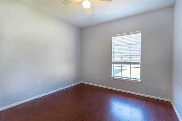 spare room featuring wood finished floors, a ceiling fan, and baseboards