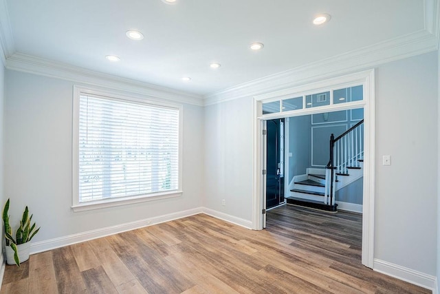 spare room with baseboards, wood finished floors, stairs, crown molding, and recessed lighting