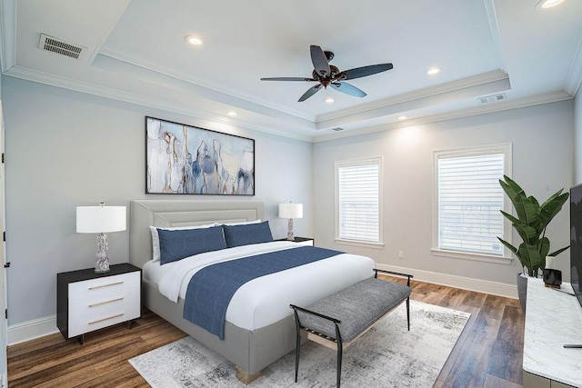 bedroom featuring baseboards, visible vents, a tray ceiling, and dark wood-style flooring