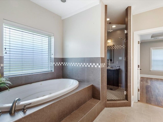 bathroom featuring tile patterned flooring, a jetted tub, and a shower stall