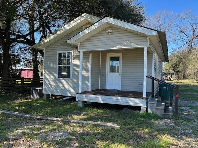 view of front of home with covered porch and fence