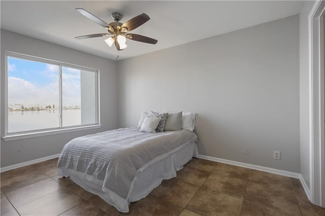 tiled bedroom with a ceiling fan and baseboards