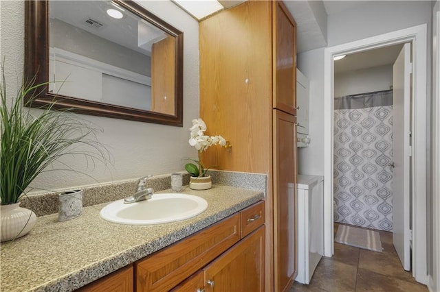 full bath with a shower with curtain, visible vents, vanity, and tile patterned floors