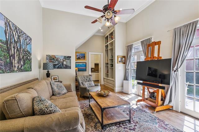 741 Esplanade Ave Unit 5, New Orleans, LA 70116 - living room with ceiling fan, plenty of natural light, a towering ceiling, wood finished floors, and ornamental molding