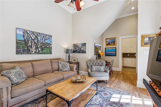 741 Esplanade Ave Unit 5, New Orleans, LA 70116 - living room with high vaulted ceiling, a ceiling fan, light wood-style floors, baseboards, and crown molding