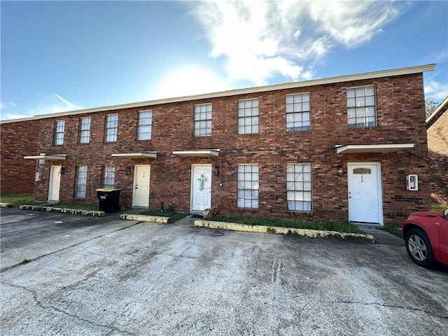 townhome / multi-family property featuring uncovered parking and brick siding