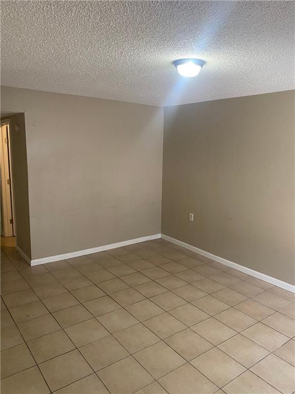 spare room with baseboards and a textured ceiling