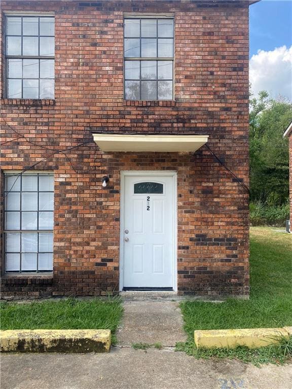 view of exterior entry featuring brick siding