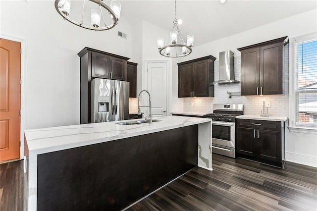 kitchen featuring stainless steel appliances, a sink, visible vents, wall chimney range hood, and plenty of natural light