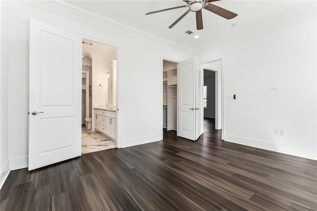 unfurnished bedroom featuring baseboards, visible vents, connected bathroom, dark wood-style floors, and crown molding