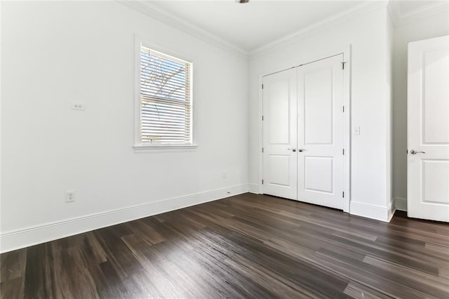 unfurnished bedroom featuring dark wood-style floors, a closet, baseboards, and crown molding