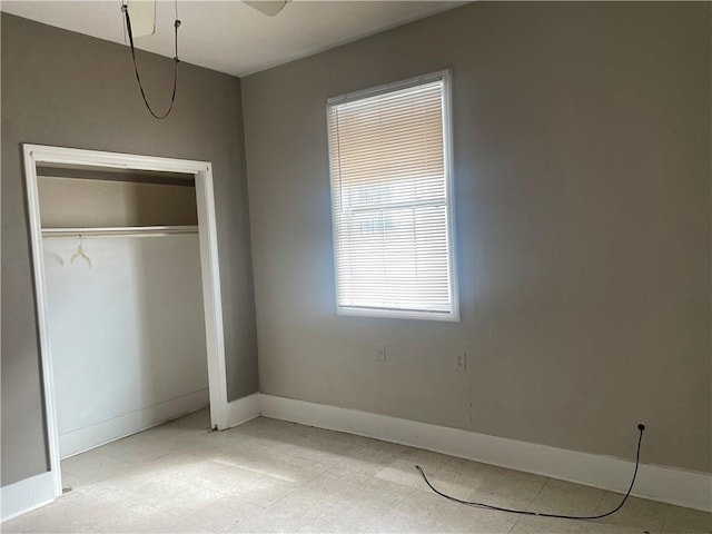 unfurnished bedroom with a closet, baseboards, and light floors