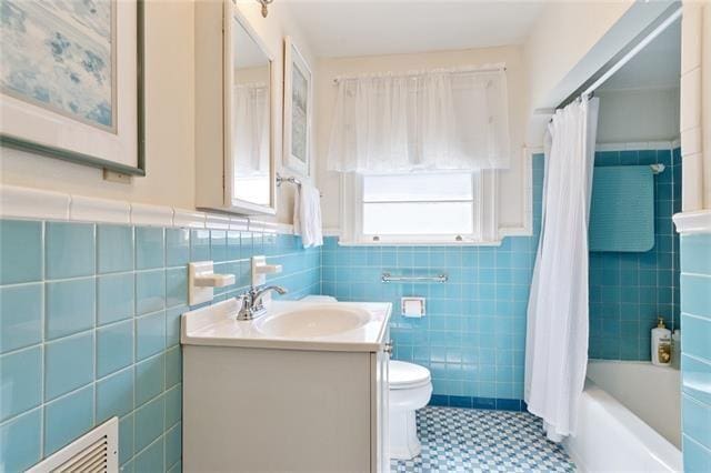 full bath featuring tile walls, visible vents, vanity, and toilet