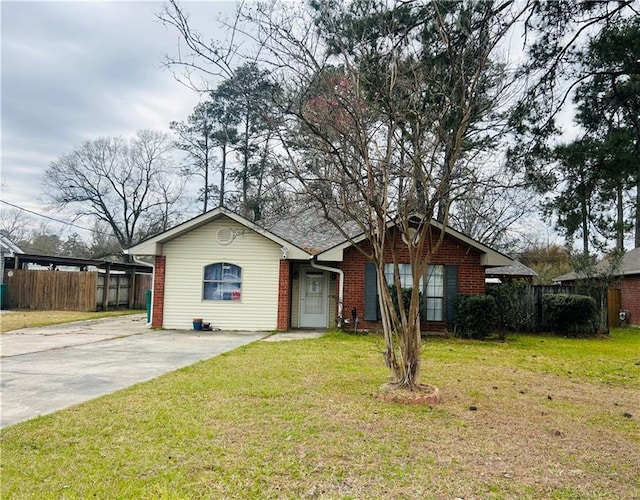 view of front of home featuring brick siding, fence, driveway, and a front lawn