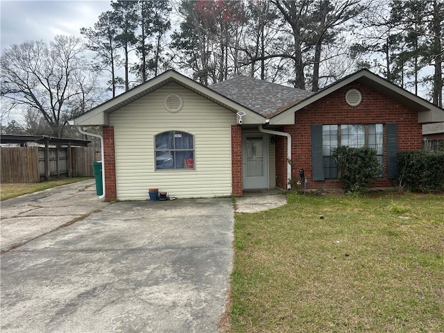 ranch-style house with a shingled roof, a front yard, fence, and brick siding