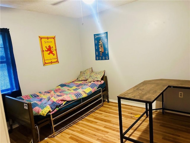 bedroom with baseboards and wood finished floors