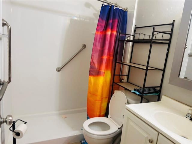 bathroom with a stall shower, vanity, and toilet