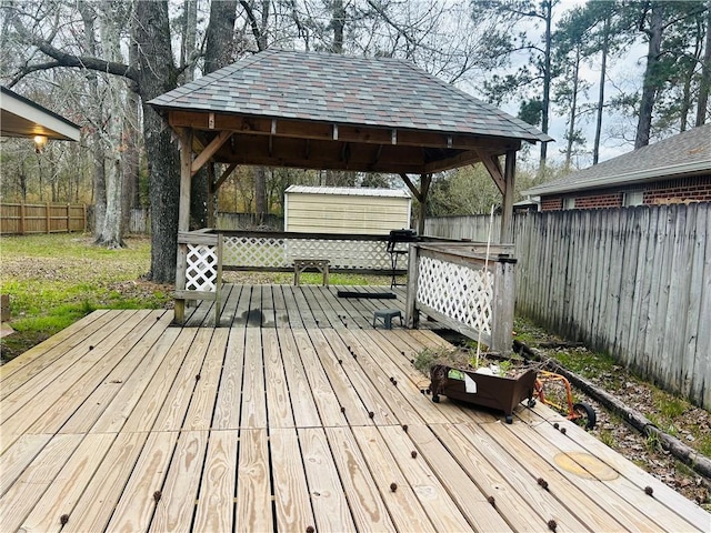 deck featuring a fenced backyard, an outdoor structure, and a storage unit