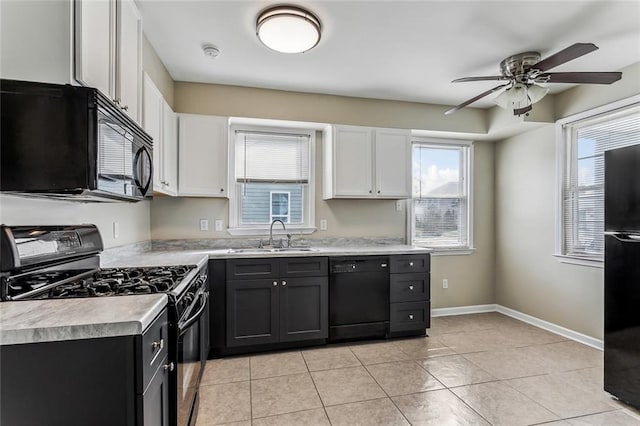 kitchen with a sink, white cabinetry, baseboards, light countertops, and black appliances