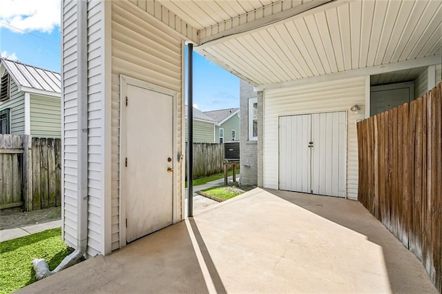 view of patio / terrace featuring a storage unit, fence, and an outdoor structure