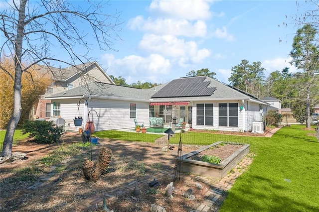 back of house featuring a patio area, cooling unit, solar panels, and a yard