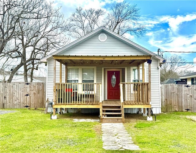 view of front of house with a porch, a front lawn, and fence