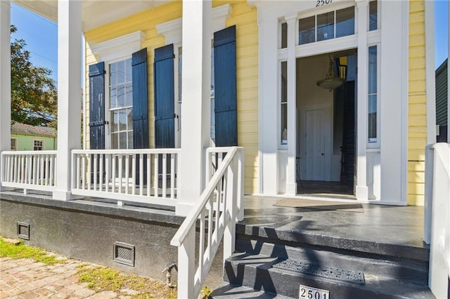 doorway to property with a porch and crawl space