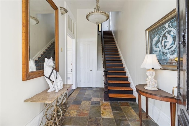 stairs featuring stone finish floor and baseboards