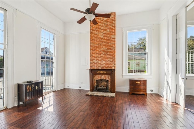 unfurnished living room with baseboards, wood-type flooring, a fireplace, and a ceiling fan