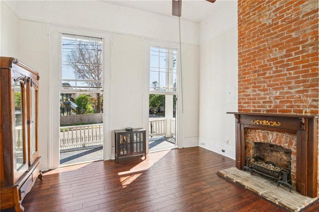 2501 Dauphine St, New Orleans, LA 70117 - unfurnished living room with hardwood / wood-style floors, a fireplace, baseboards, and ceiling fan