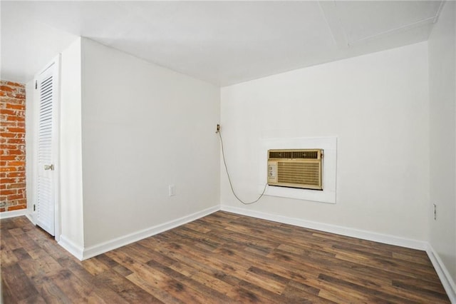2501 Dauphine St, New Orleans, LA 70117 - unfurnished room with a wall unit AC, baseboards, and dark wood-style flooring