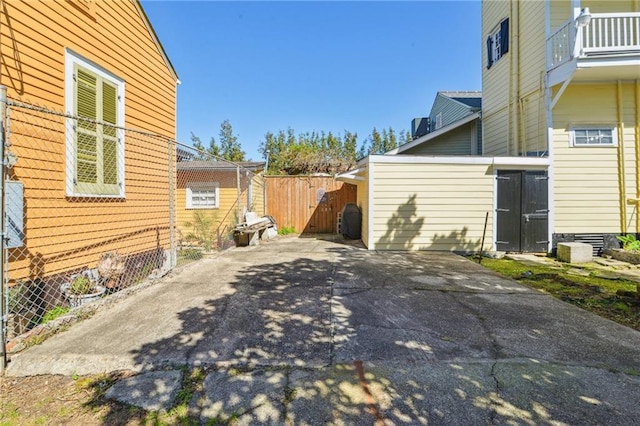 view of patio featuring an outbuilding and fence