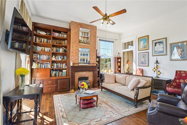 interior space with a fireplace, a ceiling fan, and wood-type flooring