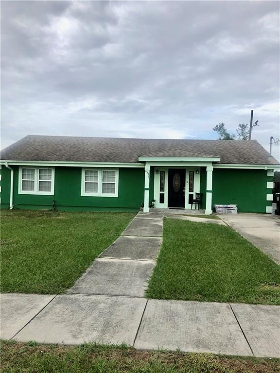 single story home with a front lawn, roof with shingles, and stucco siding