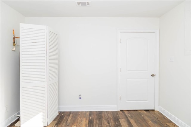 119 Ivy Dr, Covington, LA 70433 - unfurnished bedroom featuring a closet, baseboards, dark wood-style floors, and visible vents