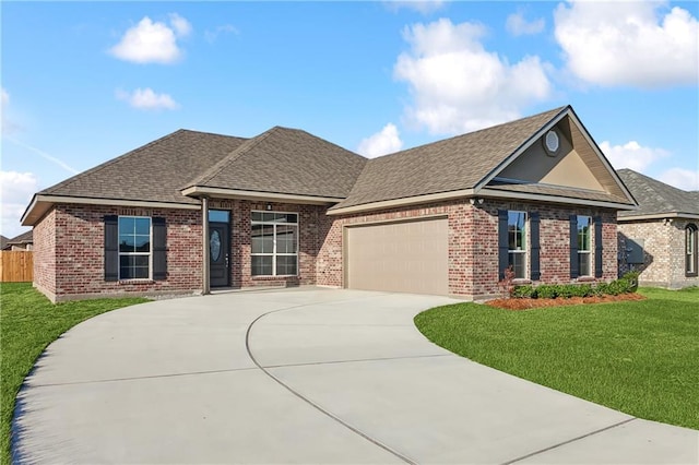 view of front of property with driveway, a shingled roof, an attached garage, a front lawn, and brick siding