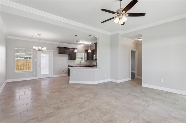 unfurnished living room with a sink, crown molding, baseboards, and ceiling fan with notable chandelier